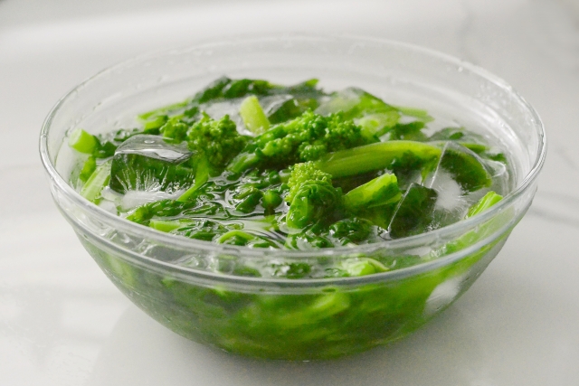 下ごしらえ中のボウルに氷水と菜の花が入った写真